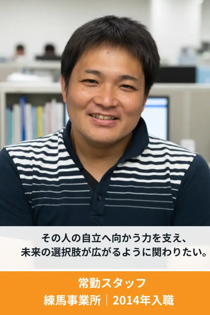 利用者支援に携わる男性スタッフが笑顔でインタビューに答えている様子