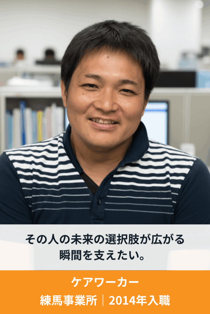 利用者支援に携わる男性スタッフが笑顔でインタビューに答えている様子