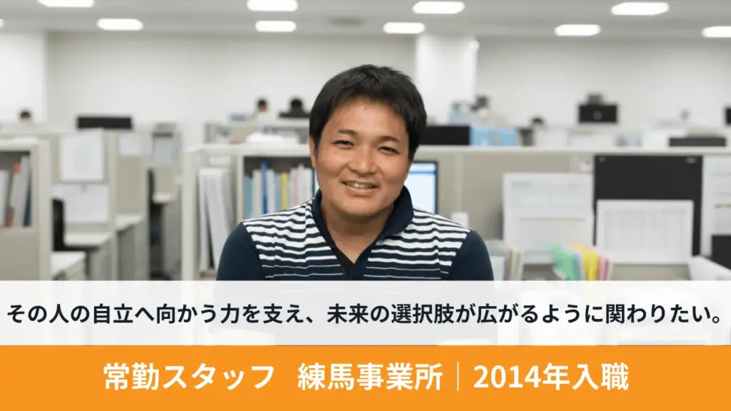 利用者支援に携わる男性スタッフが笑顔でインタビューに答えている様子