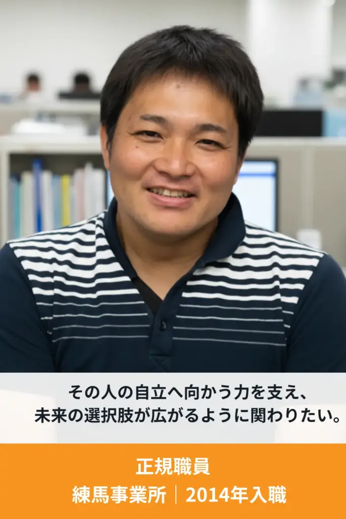 利用者支援に携わる男性スタッフが笑顔でインタビューに答えている様子